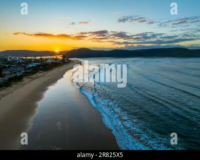 Lever de soleil avec nuages épars et petites vagues à Ocean Beach à Umina Beach sur la côte centrale, Nouvelle-Galles du Sud, Australie. Banque D'Images