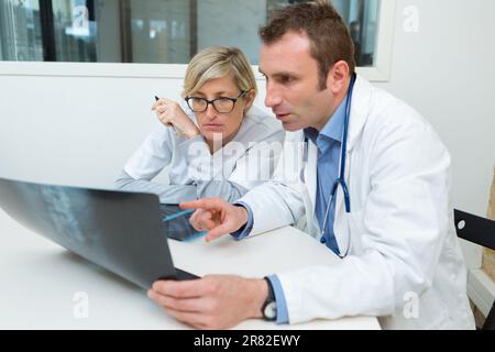 médecin de sexe féminin et masculin regardant une radiographie du genou Banque D'Images