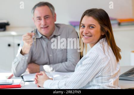 conseiller donnant des clés à une jeune femme Banque D'Images