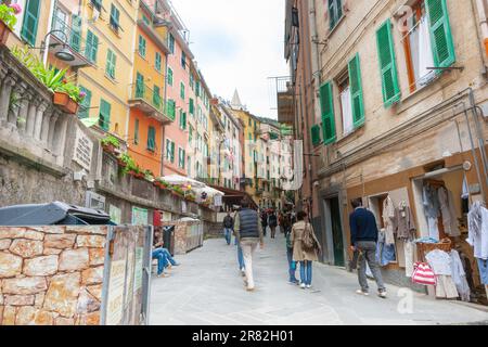 Riomaggiore Italie - 24 avril 2011 ; vue le long de la rue typique de la ville étroite avec des touristes et de hauts murs d'immeubles d'appartements. Banque D'Images