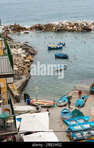 Riomaggiore Italie - 24 avril 2011 ; vue sur la petite baie des Cinque Terre avec des bateaux de pêche et des gens. Banque D'Images