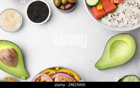 Poke Bowl et ingrédients sur table blanche, à plat. Espace pour le texte Banque D'Images