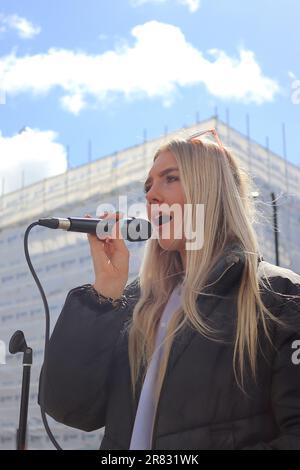 Nancy Longland un jeune soliste soprano interprète vivre aux acheteurs et aux piétons dans la Cité, zone de détail de Southampton, Hampshire, avril 2023. Banque D'Images