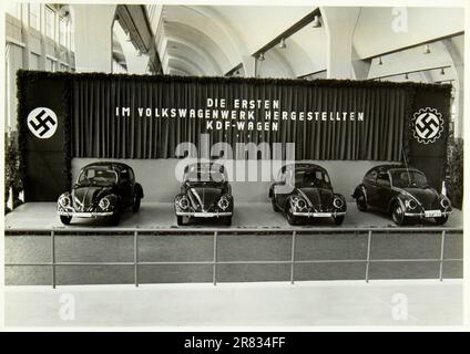 1941, ALLEMAGNE : la GUERRE en ALLEMAGNE , sous le pouvoir du dictateur de Fuhrer ADOLF HITLER ( 1889 - 1945 ), dirigeant du troisième Reich . Dans cette photo une exposition de produits de consommation modernes dans une exposition sur le progrès industriel et économique de l'Allemagne nazie, avec le stand d'exposition des derniers modèles Typ 1 de VOLKSWAGEN ( produit de 1938 - Beetle - BUG - Coccinelle ) Automobiles abordables pour la population de la classe moyenne allemande . Sur le mur a écrit: LE PREMIER KDF-WAGEN FABRIQUÉ DANS L'USINE VOLKSWAGEN . Photographe inconnu - VOITURES - USINE - PROPAGANDE - MODERNE - MODE Banque D'Images