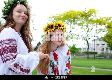 belles jeunes femmes filles tissage couronnes marche rire bavarder dans le parc dans le jardin brodé national ukrainian chemises couronnes de fleurs de tournesol et forêt blanc fleurs magnifique vyshyvanka Banque D'Images