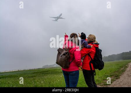 Deux femmes avec un enfant dans leurs armes regardent les avions Banque D'Images