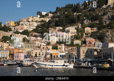 Une vue pittoresque d'une ville tranquille nichée sur le rivage de la mer dans l'île de Symi, Grèce. Banque D'Images