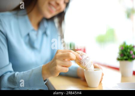 Bonne femme qui a mangé un croissant dans une tasse de café dans un restaurant Banque D'Images