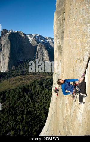 Un homme monte à El Cap tandis que son partenaire d'escalade se lagne d'un bord de mer dans le parc national de Yosemite, Californie. Banque D'Images