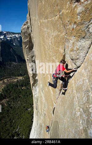 Un homme monte à El Cap tandis que son partenaire d'escalade se lagne d'un bord de mer dans le parc national de Yosemite, Californie. Banque D'Images