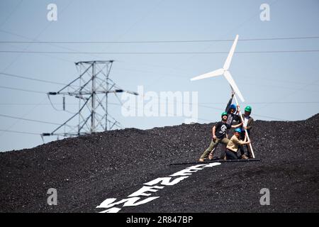 Activistes du climat avec une fausse éolienne et une bannière « énergies renouvelables maintenant » à l'intérieur d'une centrale au charbon à Boulder, Colorado. Banque D'Images