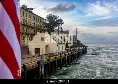 La jetée et le port de la prison fédérale de haute sécurité d'Alcatraz dans la baie de San Francisco, dans l'état de Californie, avec le drapeau des États-Unis. Banque D'Images