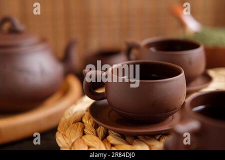 Cérémonie du thé. Ustensile traditionnel de thé asiatique, servant un set authentique. Personne versant du thé de la théière de la poterie brune à la théière. Plateau en bambou. Style de vie. Nous Banque D'Images