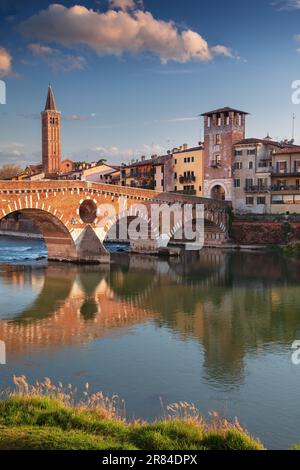 Vérone, Italie. Image de paysage urbain de la belle ville italienne de Vérone avec le pont de pierre au-dessus de la rivière Adige au coucher du soleil. Banque D'Images