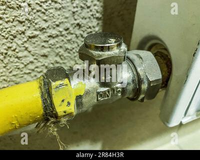 radiateur pour l'approvisionnement en chauffage des appartements résidentiels. tuyau de batterie jaune pour l'alimentation en eau chaude. communications de plomberie. Banque D'Images