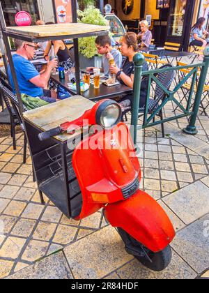 Roue avant et guidon de l'ancien scooter Chetak fabriqué dans un casier à vin au restaurant sur la place Michel Debré à Amboise, Indre-et-Loire (37), France. Banque D'Images