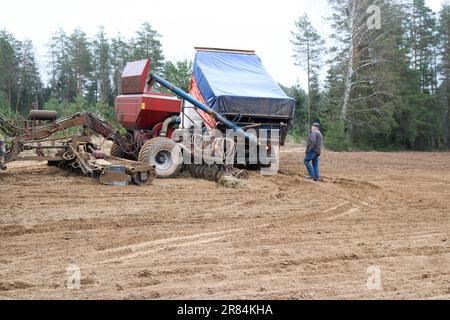 Unité de semis, moissonneuse-batteuse, semoir et camion, tombereau sur le terrain. Banque D'Images