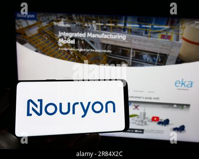 Personne tenant un téléphone portable avec le logo de la société néerlandaise Nouryon Chemicals Holding BV à l'écran en face de la page Web d'affaires. Mise au point sur l'affichage du téléphone. Banque D'Images