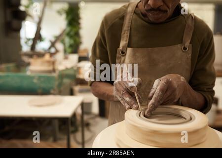 Céramiste africain façonnant l'argile dans un moule tournant sur une roue de poterie Banque D'Images