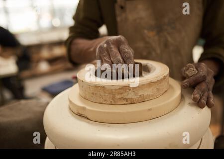 Céramiste africain moulant de l'argile sur une roue de poterie dans un studio Banque D'Images