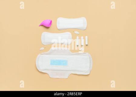 Composition avec coussinets menstruels, tasse et tampons sur fond beige Banque D'Images