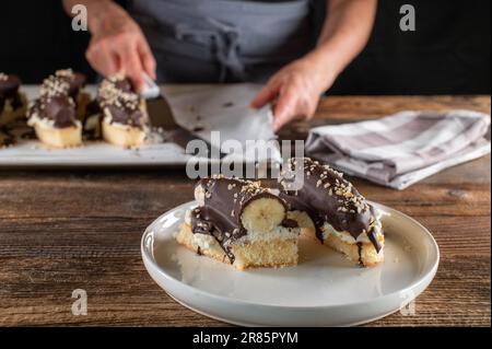 Dessert de banane au chocolat avec bananes entières, crème fouettée et base de gâteau éponge Banque D'Images