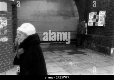 Brighton a fait froid l'hiver, deux femmes âgées se promenant ensemble et un jeune couple s'embrassant dans un coin hors du vent. Brighton, Sussex, Angleterre vers 1969. 1960S ROYAUME-UNI HOMER SYKES Banque D'Images