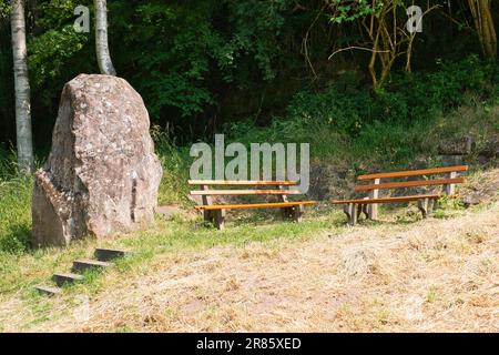 Deux bancs en bois à côté d'un grand menhir et d'un petit escalier en bordure de la Forêt Noire en Allemagne Banque D'Images