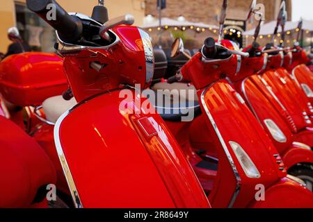 Groupe de scooters Vespa rouges garés. Location de scooter en ville. Banque D'Images