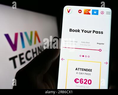 Personne tenant un téléphone portable avec la page web de la conférence française Viva Technology (VivaTech) à l'écran avec logo. Concentrez-vous sur le centre de l'écran du téléphone. Banque D'Images