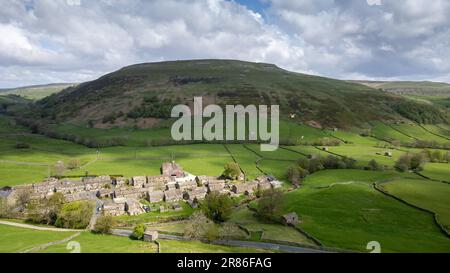 Hameau de Thwaite à l'extrémité supérieure de Swaledale, avec la colline de Kisdon à l'arrière, en début d'été. Parc national de Yorkshire Dales, Royaume-Uni. Banque D'Images