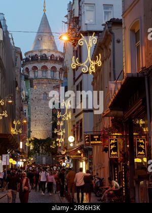 Les touristes dans la rue en dessous de la Tour Galata dans la soirée et les touristes profitant de la vue de la tour, Istanbul, Turquie Banque D'Images