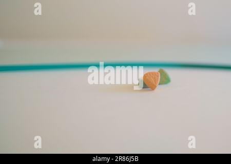 Pilules d'ecstasy de Tesla de couleur orange, verte et bleue en forme de bouclier avec le logo de Tesla; 240 milligrammes de MDMA récréatif ou Molly; drogues Banque D'Images