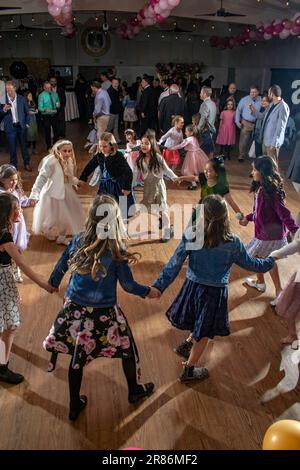 Les filles de l'école moyenne dansent à un père et des filles dansent dans une salle de gym de l'école catholique du sud de la Californie. Banque D'Images