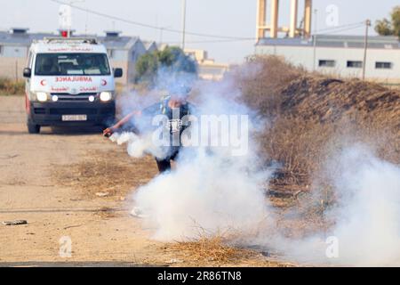 Gaza. 19th juin 2023. Un manifestant palestinien jette une bombe à gaz lacrymogène tirée par un soldat israélien lors d'une protestation contre le meurtre de cinq Palestiniens près de la clôture de la frontière Gaza-Israël, à l'est de la ville de Gaza, sur 19 juin 2023. La Palestine a condamné lundi le meurtre de cinq Palestiniens par l'armée israélienne et des dizaines d'autres blessés lors d'un raid dans la ville de Djénine, dans le nord de la Cisjordanie, et dans son camp de réfugiés. Credit: Rizek Abdeljawad/Xinhua/Alamy Live News Banque D'Images