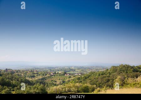 Photo d'un panorama de la campagne serbe pendant un ciel bleu ensoleillé après-midi d'été, avec fermes, maisons et champs, à Sopot, Serbie, en milieu rural Banque D'Images