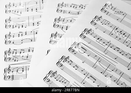 Feuilles de musique. Mélodies écrites avec différents symboles musicaux comme fond, gros plan Banque D'Images