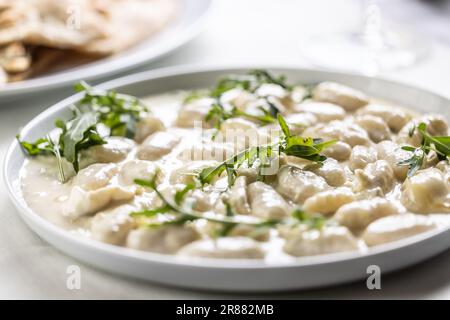 Gnocchi ai quattro formaggi, pâtes italiennes à la pâte avec quatre types de fromage et rockla sur le dessus. Banque D'Images