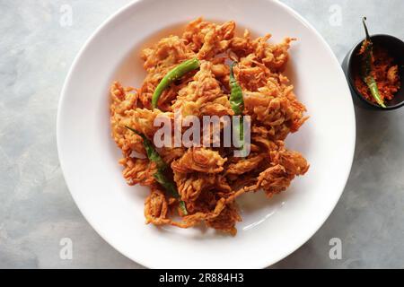 Pakode à l'oignon frit ou Pyaj ke Pakore également connu sous le nom Crispy Kanda bhaji, Bhajji, bujji. En-cas indien préféré à l'heure du thé pendant la mousson. Banque D'Images