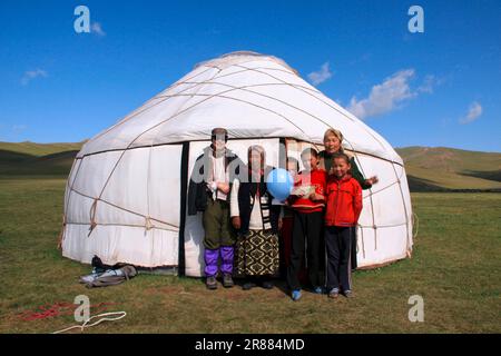 Famille Shepherd avec un touriste en face de leur yourte à Songkoel Kirghizistan Banque D'Images