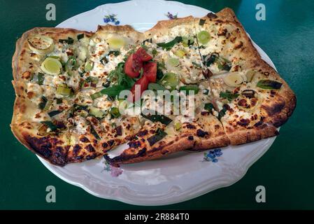 Flammkuchen aux épinards et au fromage feta, servi un peu brûlé dans un jardin widrtschaft, Franconie, Bavière, Allemagne Banque D'Images