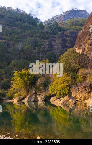 L'eau verte émeraude de la rivière Nine Bend ou de la rivière Jiuxi à travers Wuyishan ou le mont wuyi région pittoresque dans la province de Fujian en Chine. Arrière-plan du coucher du soleil Banque D'Images