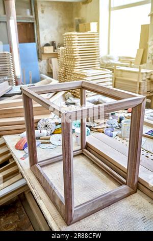 Cadre en bois de table de chevet en noyer massif dans l'atelier. Menuiserie joint angulaire de planches sur les chevilles Banque D'Images