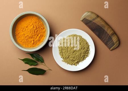 Composition de couche plate avec henné et poudre curcuma sur fond de corail. Coloration naturelle des cheveux Banque D'Images