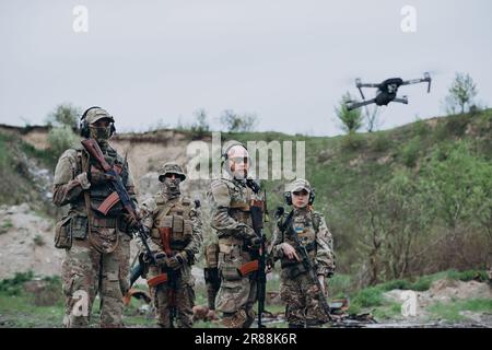 Quatre soldats ukrainiens armés regardant dans la caméra avec un drone Banque D'Images