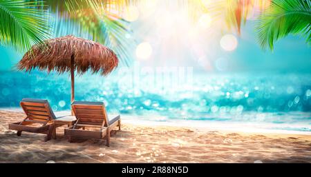 Chaises longues avec parasol et feuilles de palmier dans Tropical Beach avec sable et océan ensoleillé - Abstract Defocased Seascape et effets étincelants Banque D'Images