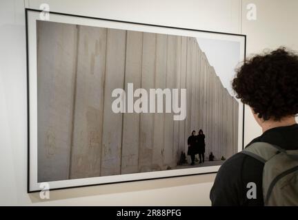 Jérusalem. 19th juin 2023. Un visiteur regarde une photo exposée sur une exposition de photographie avec le thème de "et dans son coeur il y a un mur" à Jérusalem sur 19 juin 2023. En juin 2002, Israël a commencé à construire un mur de séparation sur les terres palestiniennes adjacentes aux frontières entre Israël et la Cisjordanie, affirmant que le mur empêcherait les militants palestiniens d'entrer en Israël pour mener des attaques. Credit: Chen Junqing/Xinhua/Alay Live News Banque D'Images