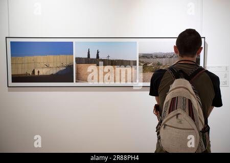 Jérusalem. 19th juin 2023. Un visiteur regarde les photos affichées sur une exposition de photographie avec le thème "et dans son coeur il y a un mur" à Jérusalem sur 19 juin 2023. En juin 2002, Israël a commencé à construire un mur de séparation sur les terres palestiniennes adjacentes aux frontières entre Israël et la Cisjordanie, affirmant que le mur empêcherait les militants palestiniens d'entrer en Israël pour mener des attaques. Credit: Chen Junqing/Xinhua/Alay Live News Banque D'Images