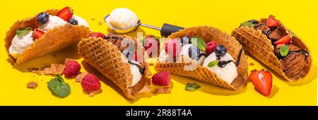 Diverses crèmes glacées au taco sucré. Coquilles de tacos à gaufrer avec glace au chocolat et à la vanille avec différents fruits, baies, garnitures Banque D'Images