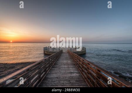 Le matin sur la jetée et le rond-point surplombant la mer avec les splendides couleurs du lever du soleil Banque D'Images